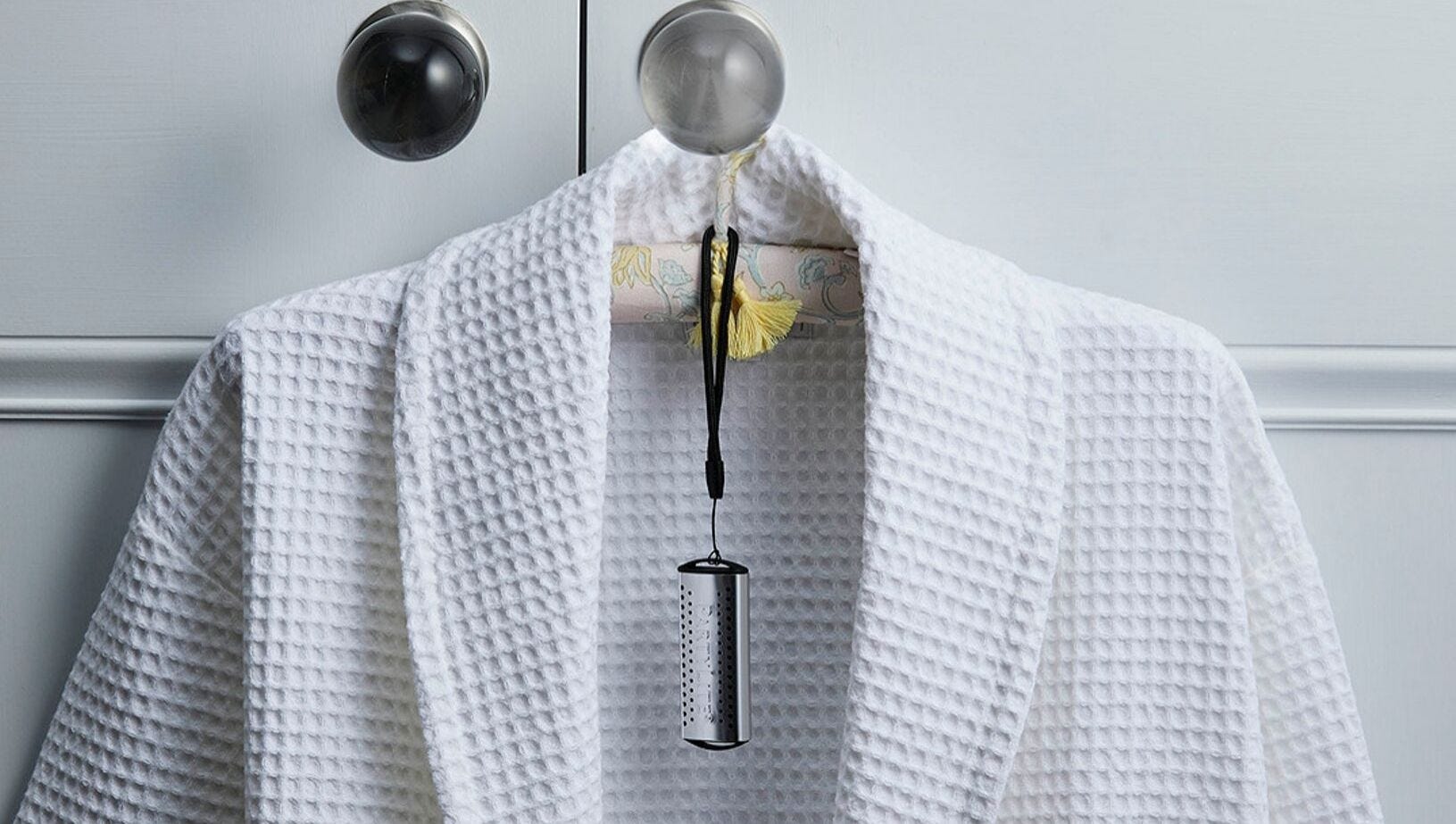 GoSmart‚™ Mobile Fragrance Holder hanging on a hanger with a robe.